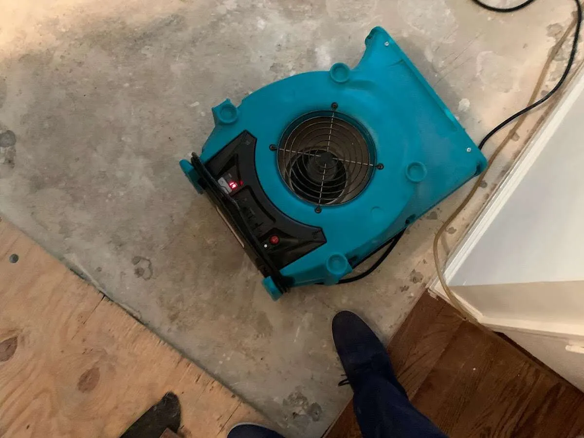 Air mover drying subfloor during Commercial Water Damage Restoration in St. Gabriel